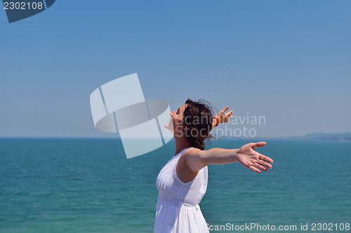 Image of young woman with spreading arms to sky