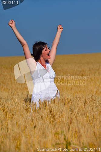 Image of young woman in wheat field at summer