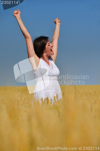 Image of young woman in wheat field at summer