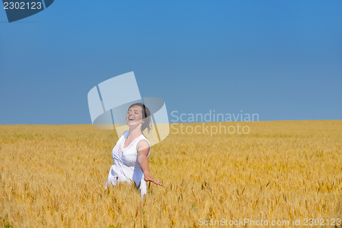 Image of young woman in wheat field at summer