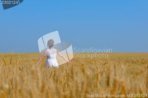 Image of young woman in wheat field at summer