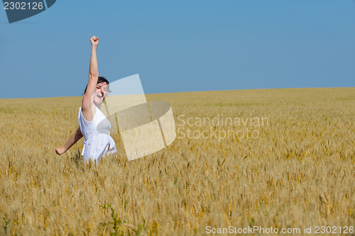 Image of young woman in wheat field at summer