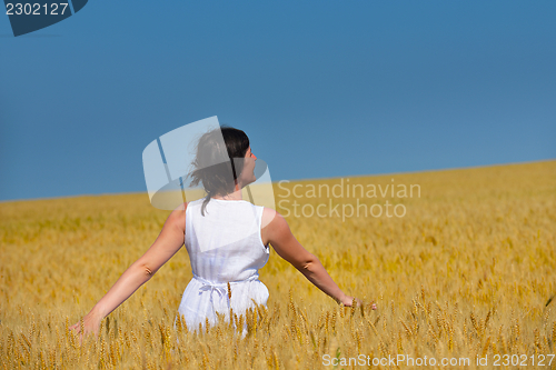 Image of young woman in wheat field at summer