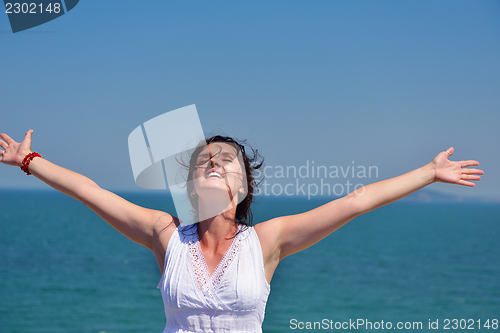 Image of young woman with spreading arms to sky