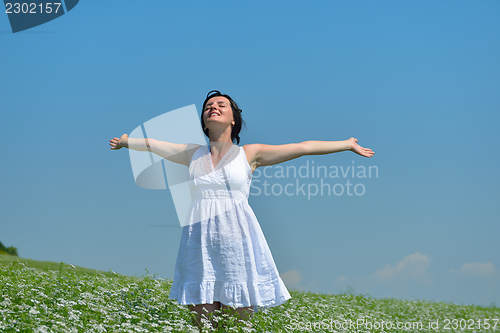 Image of Young happy woman in green field