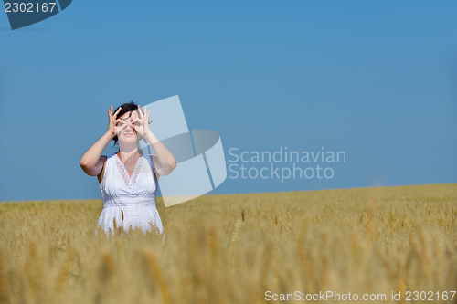 Image of young woman in wheat field at summer