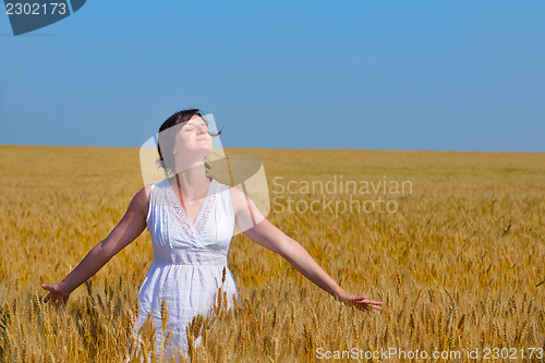 Image of young woman in wheat field at summer