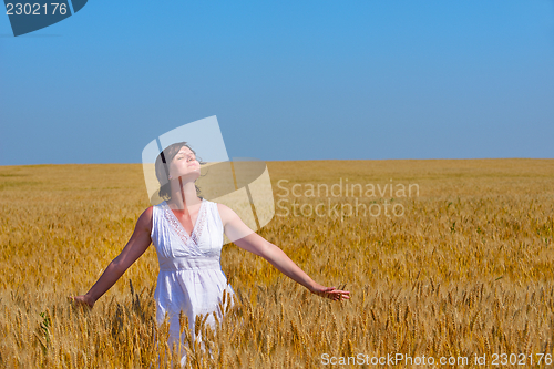 Image of young woman in wheat field at summer