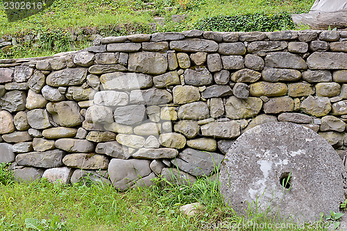 Image of Stone wall and green grass in the backyard