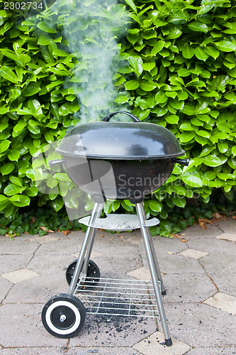 Image of Old black barbecue being used