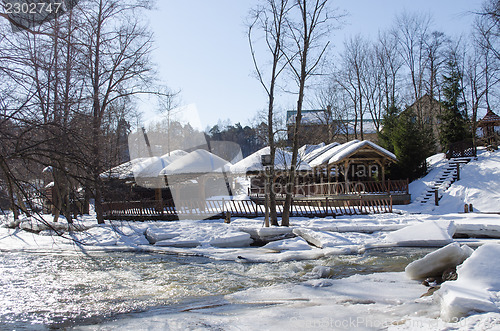 Image of frozen river bank wooden village houses roof snow 