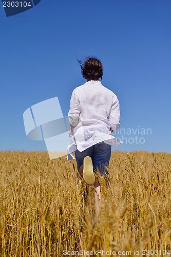Image of young woman in wheat field at summer
