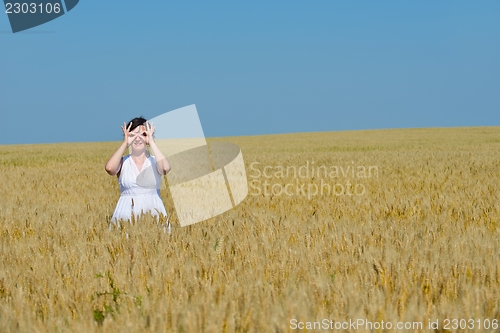Image of young woman in wheat field at summer