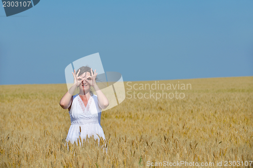 Image of young woman in wheat field at summer