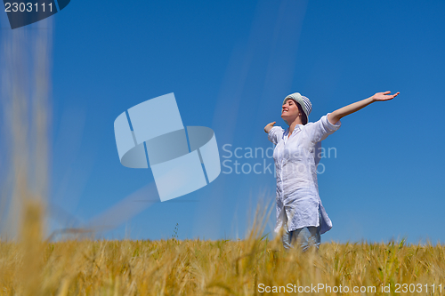 Image of young woman in wheat field at summer