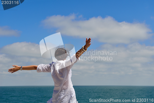 Image of young woman with spreading arms to sky