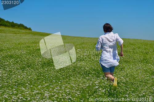 Image of Young happy woman in green field