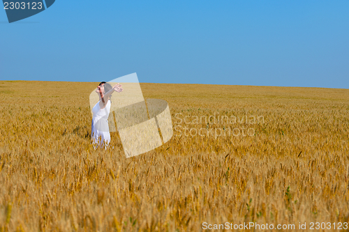 Image of young woman in wheat field at summer