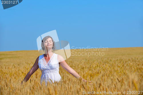 Image of young woman in wheat field at summer