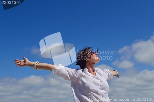 Image of young woman with spreading arms to sky