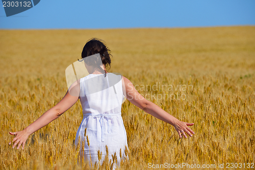 Image of young woman in wheat field at summer