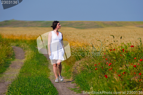 Image of Young happy woman in green field