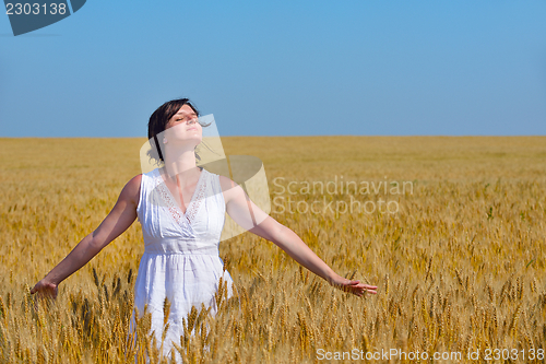 Image of young woman in wheat field at summer