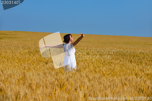Image of young woman in wheat field at summer