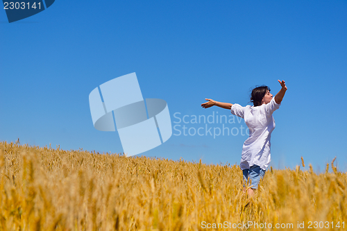 Image of young woman in wheat field at summer