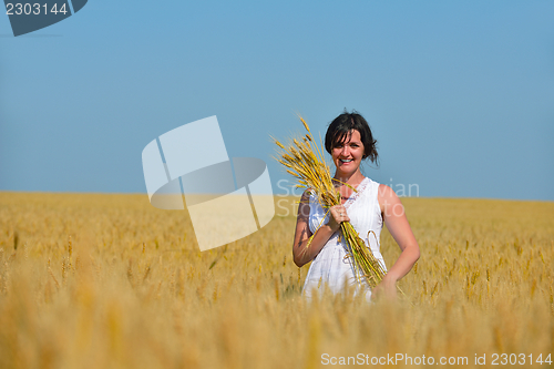 Image of young woman in wheat field at summer