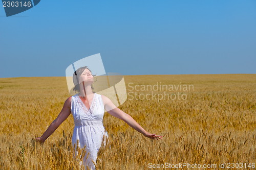 Image of young woman in wheat field at summer