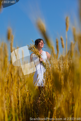 Image of young woman in wheat field at summer