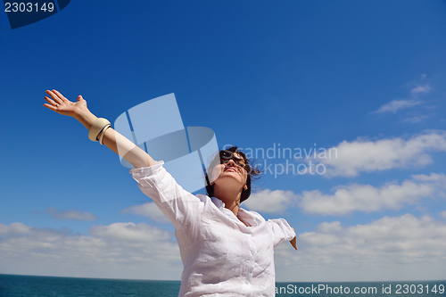 Image of young woman with spreading arms to sky