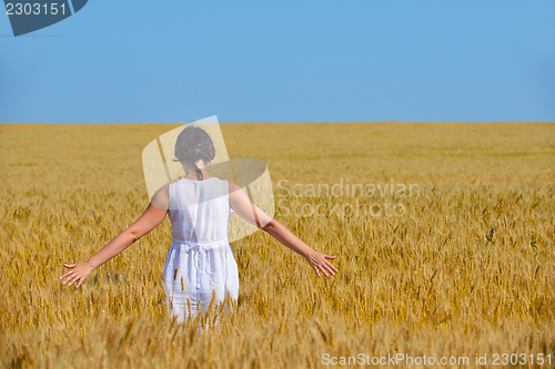 Image of young woman in wheat field at summer