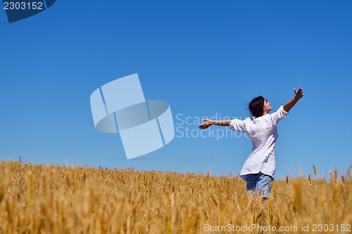 Image of young woman with spreading arms to sky