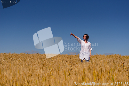 Image of young woman in wheat field at summer