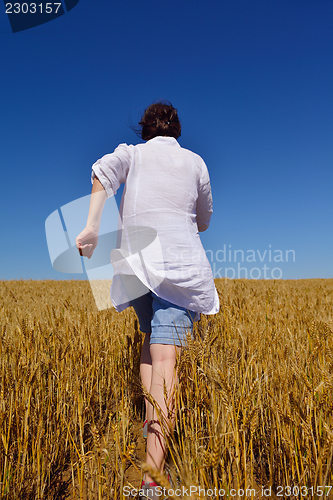 Image of young woman in wheat field at summer
