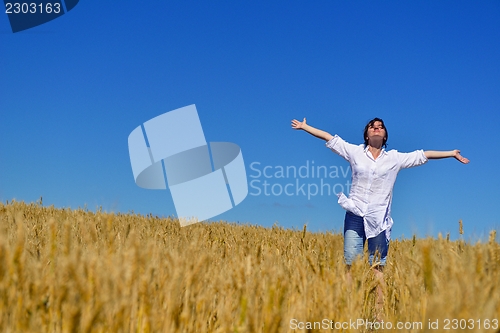 Image of young woman in wheat field at summer