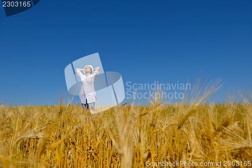 Image of young woman in wheat field at summer