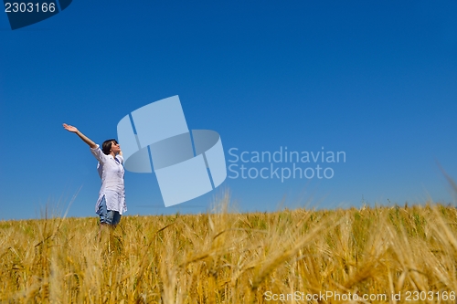 Image of young woman in wheat field at summer