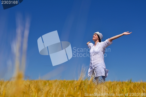 Image of young woman in wheat field at summer