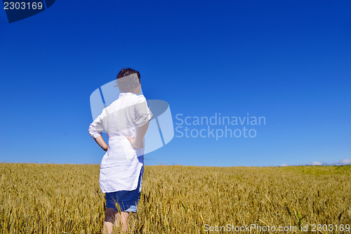 Image of young woman in wheat field at summer