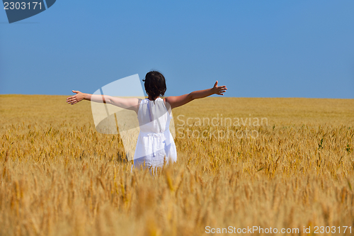 Image of young woman in wheat field at summer