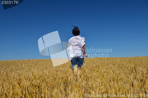 Image of young woman in wheat field at summer