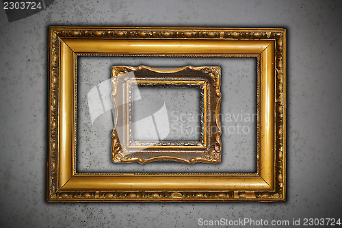 Image of two ancient empty frames on grungy wall