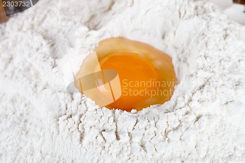 Image of broken egg on flour 