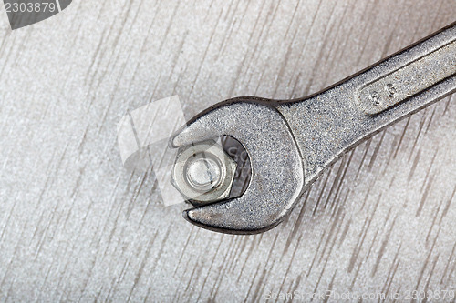 Image of Wrench, bolt and nut on metal surface