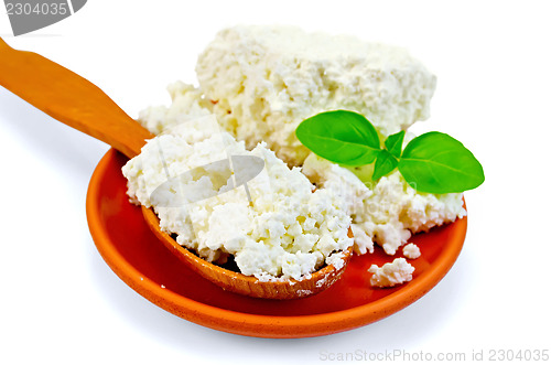 Image of Curd in a wooden spoon and a clay plate