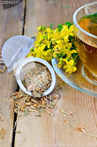 Image of Herbal tea from tutsan dry in strainer with cup