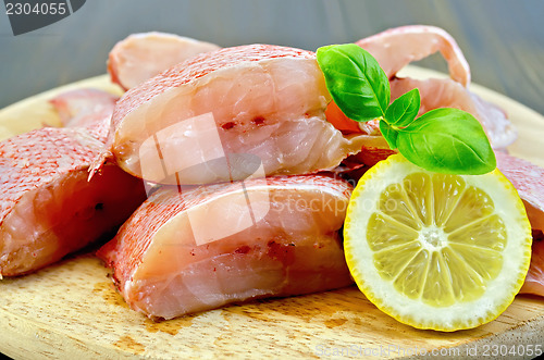 Image of Fillet of sea bass with lemon and basil on board